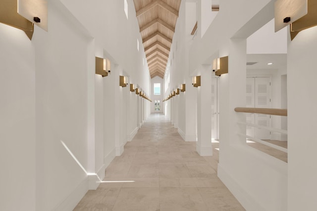 hallway featuring light tile floors and a high ceiling