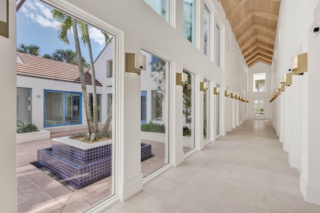 interior space with light tile flooring and a towering ceiling