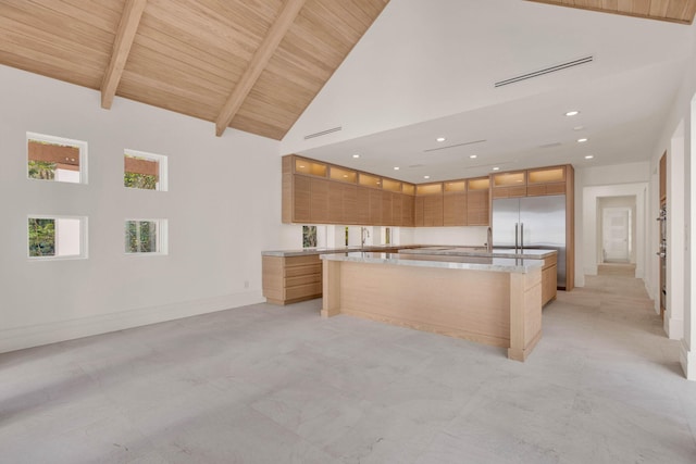 kitchen featuring built in refrigerator, high vaulted ceiling, wooden ceiling, and an island with sink