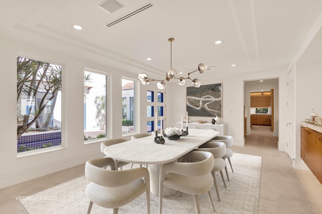 tiled dining space with a raised ceiling, a notable chandelier, and a wealth of natural light