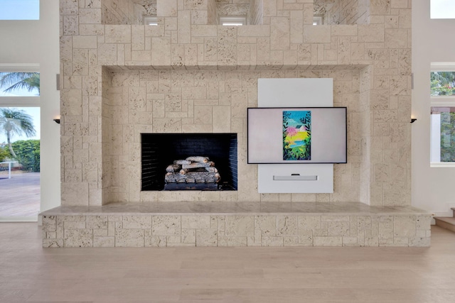 interior details with a tile fireplace and hardwood / wood-style flooring