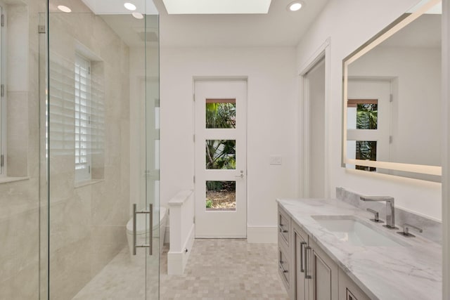 bathroom featuring toilet, vanity, and a healthy amount of sunlight