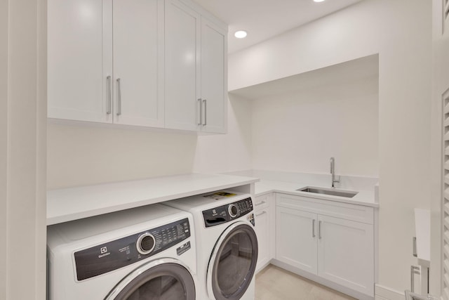 laundry room with washer and clothes dryer, cabinets, and sink