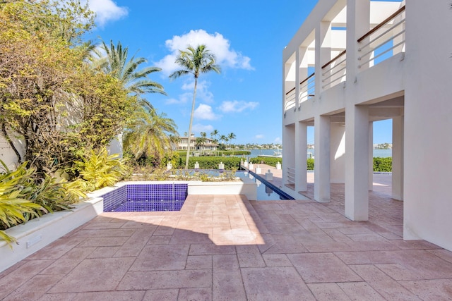 view of swimming pool featuring a patio area and a water view