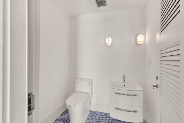 bathroom with toilet and tile floors