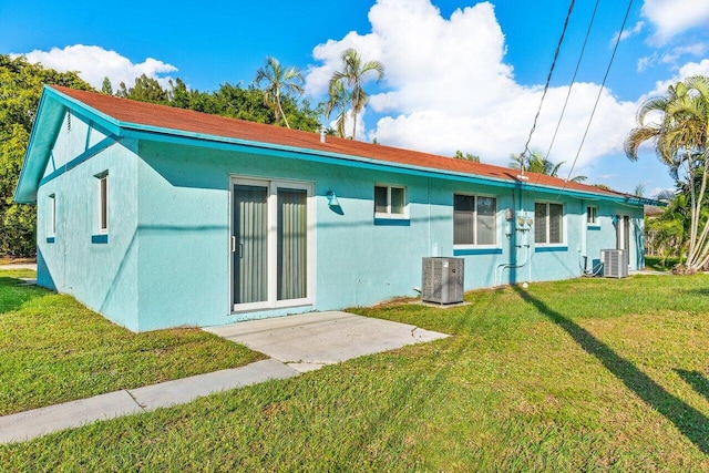 rear view of property featuring a lawn and central AC