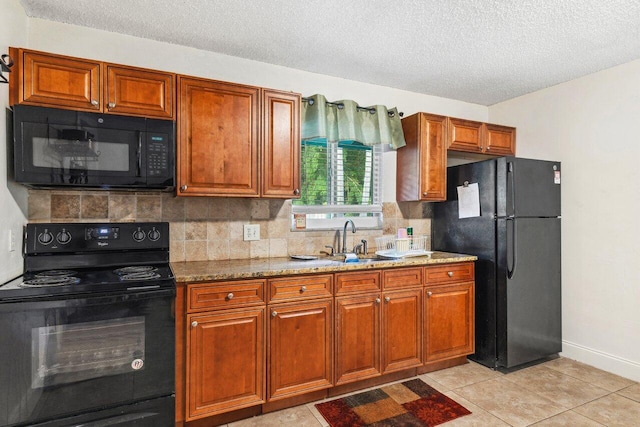 kitchen featuring black appliances, sink, a textured ceiling, light tile patterned floors, and light stone counters