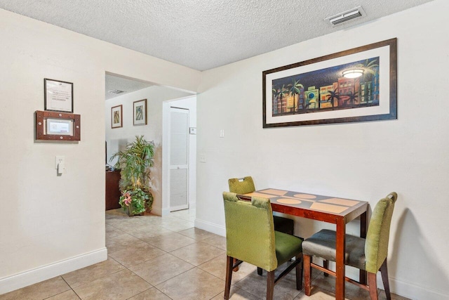 tiled dining room with a textured ceiling