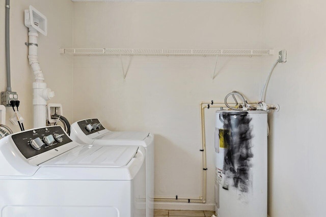 clothes washing area featuring water heater and washer and dryer