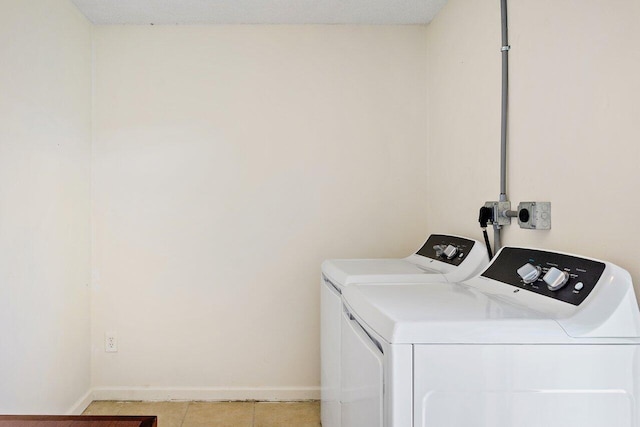 washroom featuring washer and clothes dryer and light tile patterned floors