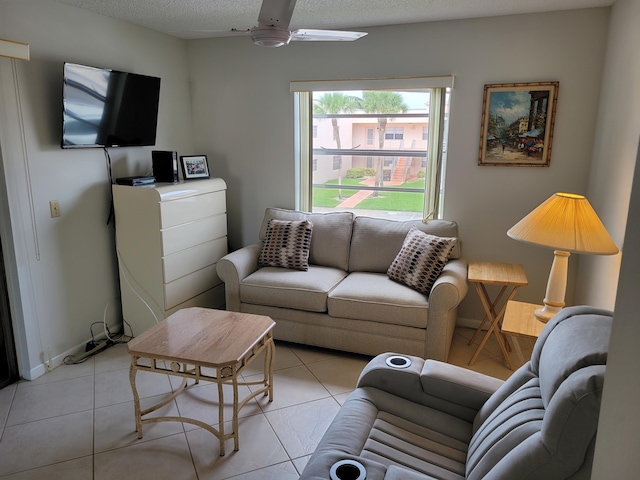 living room with a textured ceiling, ceiling fan, and light tile floors