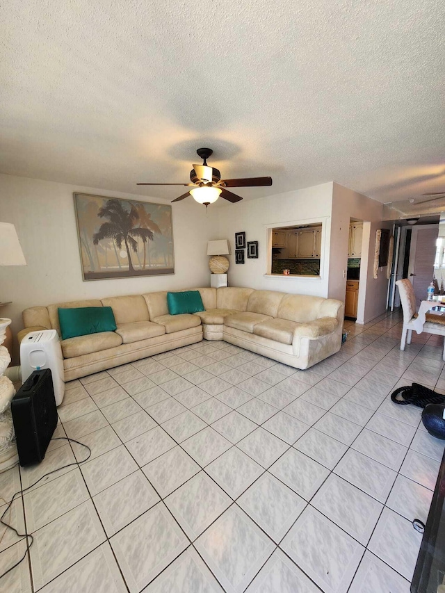 living room featuring a textured ceiling, ceiling fan, and light tile flooring