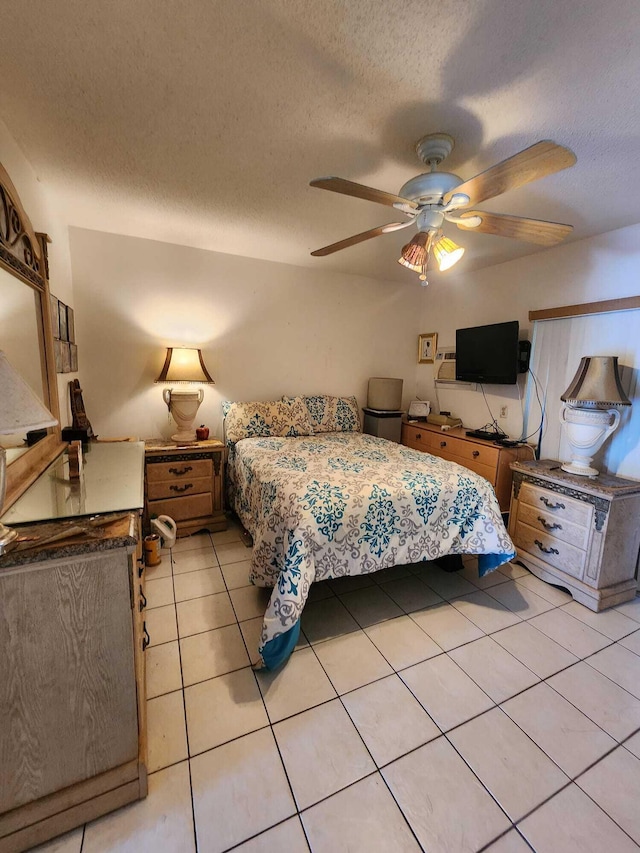 bedroom featuring a textured ceiling, light tile flooring, and ceiling fan