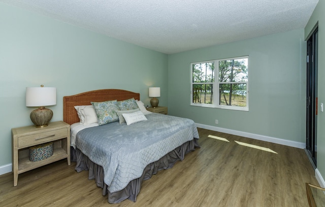 bedroom with a textured ceiling and hardwood / wood-style floors