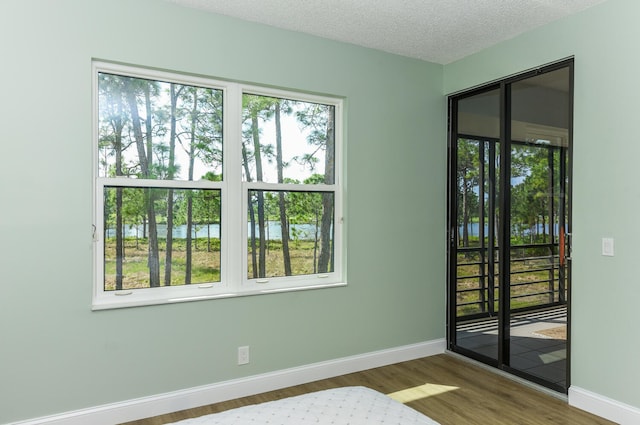 empty room featuring a textured ceiling and hardwood / wood-style floors