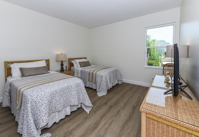 bedroom featuring a textured ceiling and dark wood-type flooring