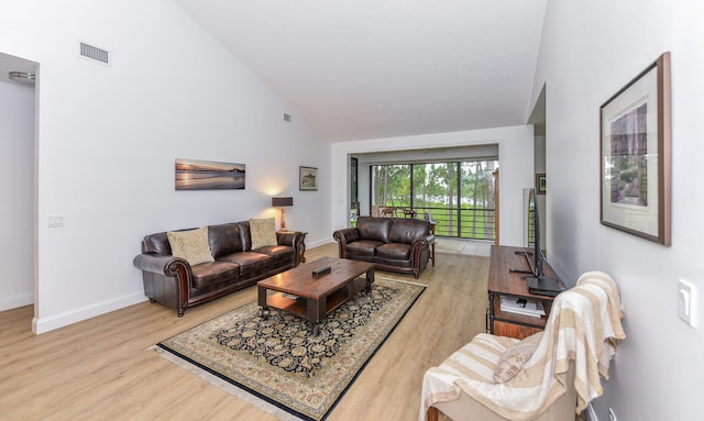 living room with high vaulted ceiling and hardwood / wood-style floors