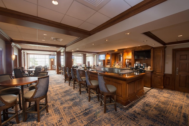 bar featuring ornamental molding, carpet floors, and decorative columns