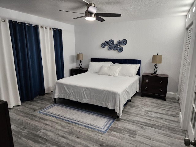 bedroom featuring a textured ceiling, hardwood / wood-style flooring, and ceiling fan