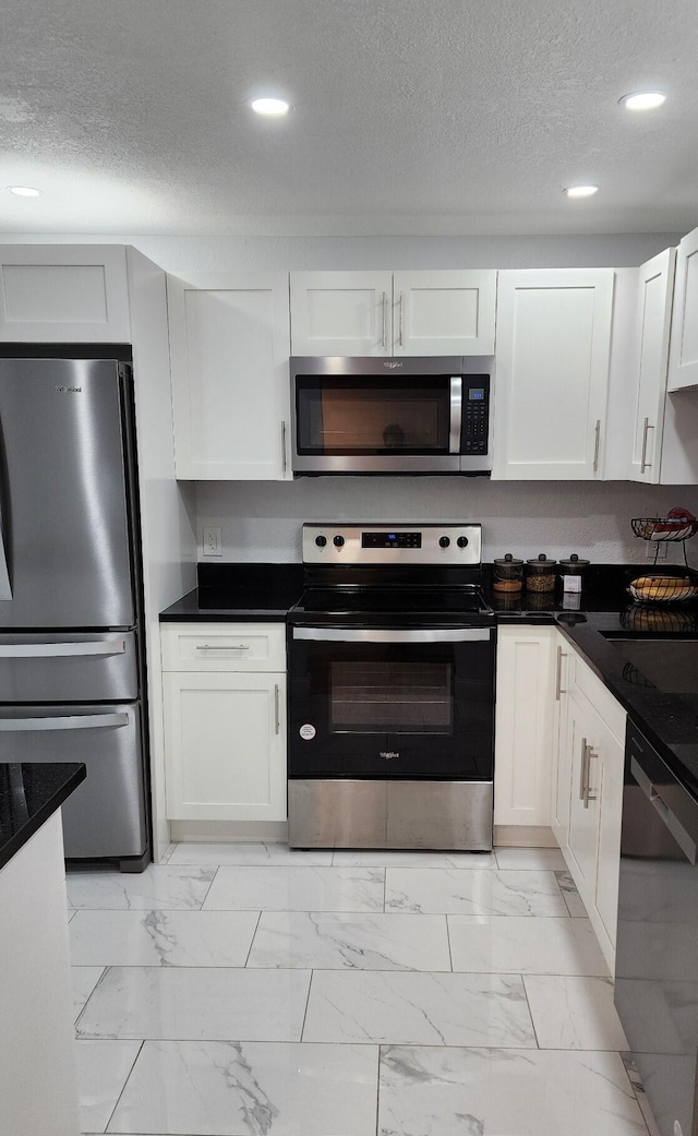 kitchen featuring appliances with stainless steel finishes, a textured ceiling, and white cabinetry