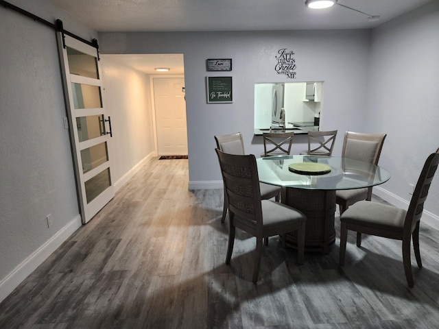 dining room featuring hardwood / wood-style floors, a barn door, and sink