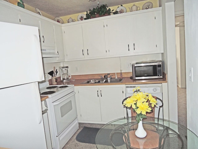 kitchen with white appliances, sink, white cabinets, a textured ceiling, and exhaust hood