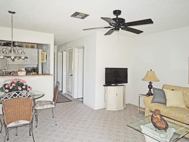 carpeted living room featuring a textured ceiling and ceiling fan