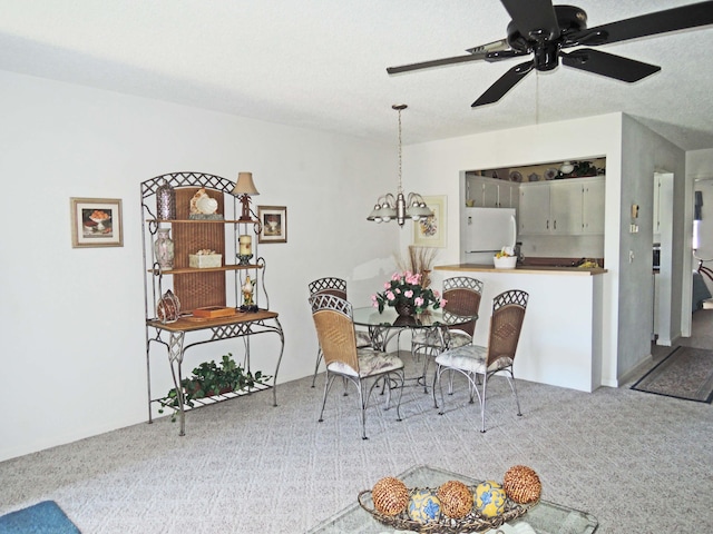 dining room featuring carpet flooring and ceiling fan with notable chandelier