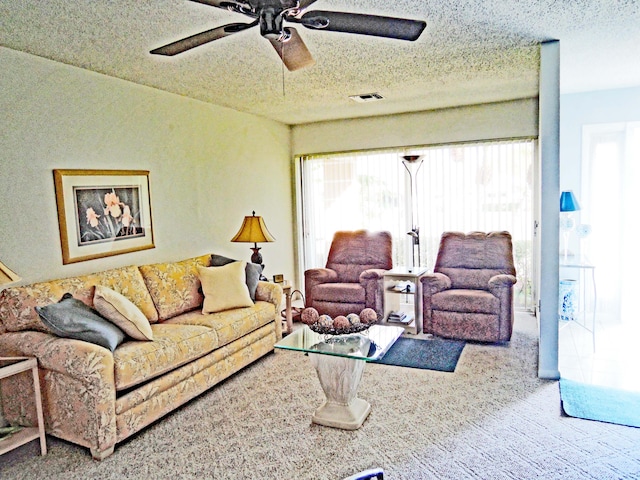 living room featuring carpet flooring, a textured ceiling, and ceiling fan