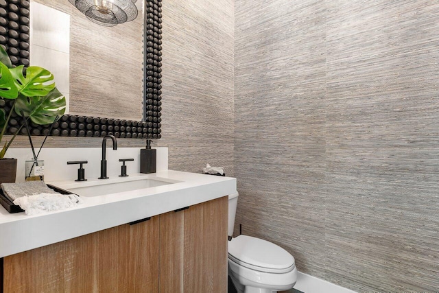 bathroom featuring vanity, toilet, and tile walls