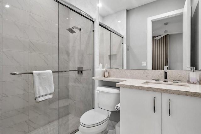 bathroom featuring vanity, a shower with shower door, and toilet