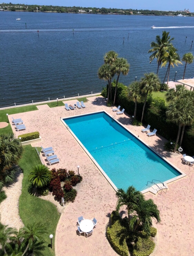 pool featuring a patio area and a water view