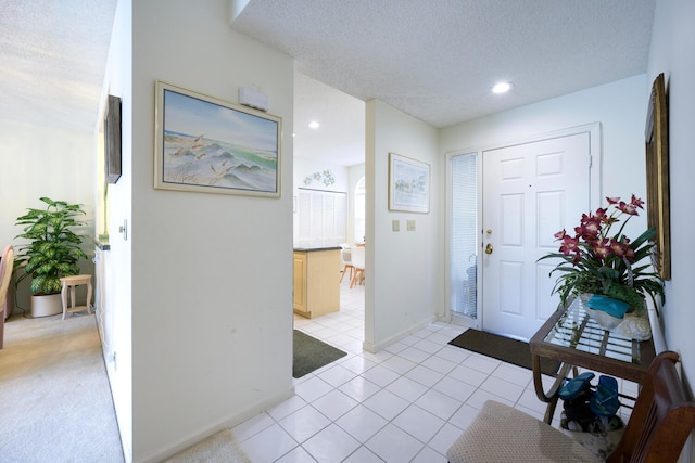 entryway with a textured ceiling and light tile floors