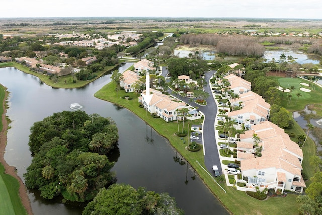 back of property featuring a balcony, a lawn, and a water view