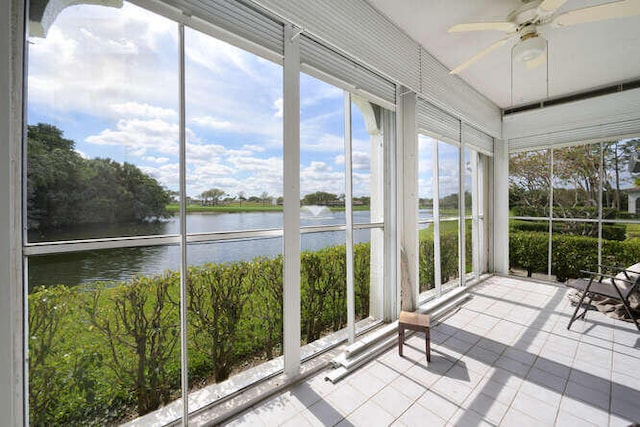 unfurnished sunroom with ceiling fan and a water view