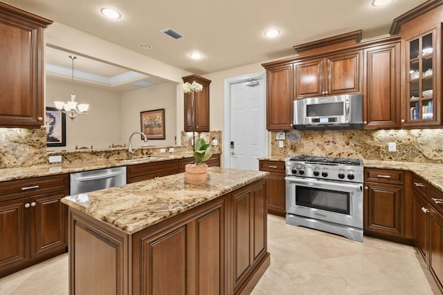 kitchen with pendant lighting, appliances with stainless steel finishes, sink, and backsplash