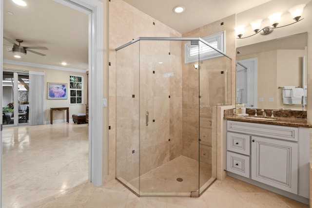 bathroom with a shower with door, vanity, crown molding, and ceiling fan