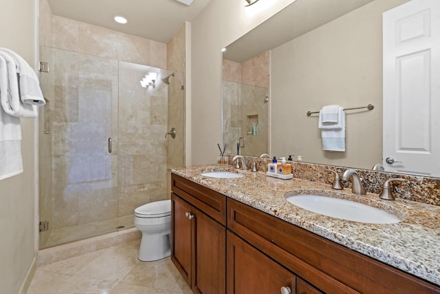 bathroom featuring a shower with door, vanity, tile patterned floors, and toilet