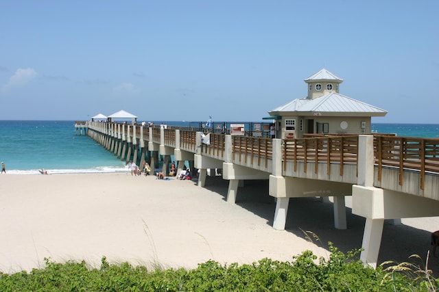 dock area with a water view and a beach view