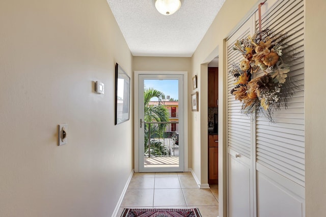 entryway with light tile patterned flooring and a textured ceiling