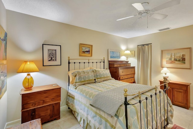 tiled bedroom featuring ceiling fan and a textured ceiling