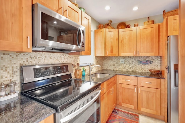 kitchen featuring tasteful backsplash, sink, dark stone counters, and appliances with stainless steel finishes