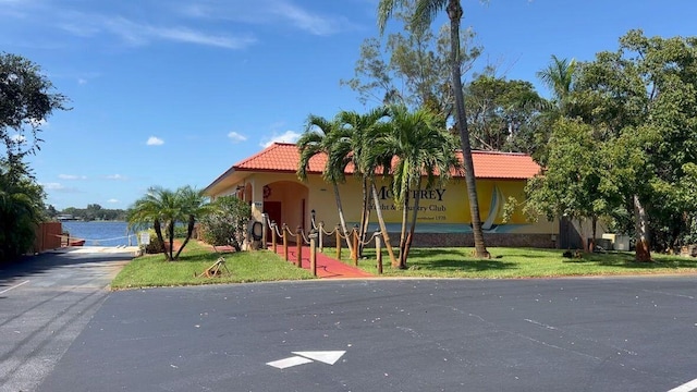 view of front of home with a water view and a front lawn