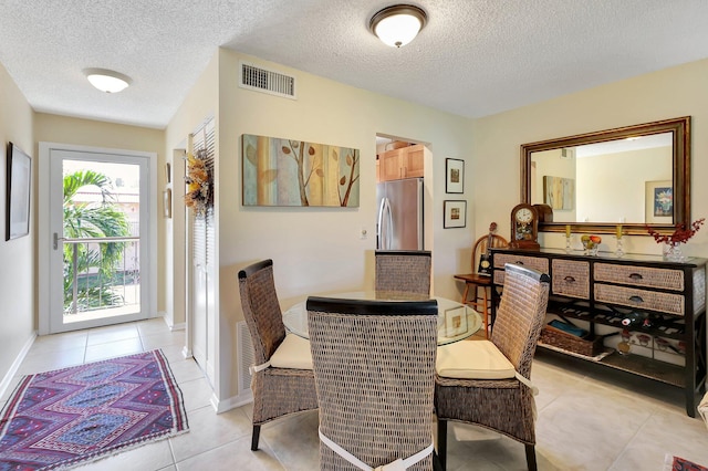 tiled dining area with a textured ceiling