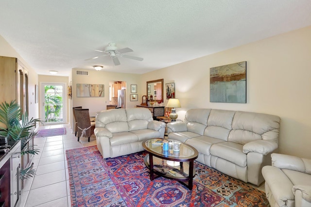 tiled living room featuring ceiling fan and a textured ceiling