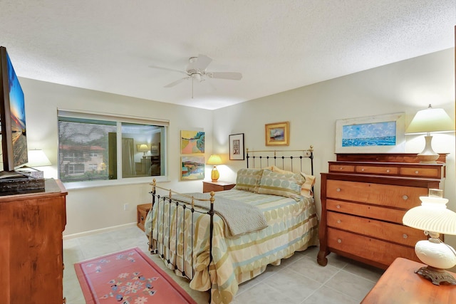 tiled bedroom with ceiling fan and a textured ceiling