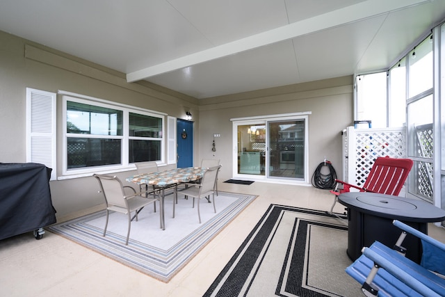 sunroom featuring beam ceiling