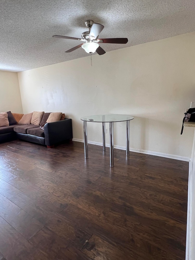 unfurnished living room with a textured ceiling, ceiling fan, and dark wood-type flooring