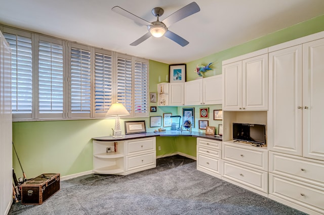 office space with ceiling fan, built in desk, and light carpet