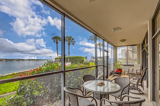 sunroom featuring a water view